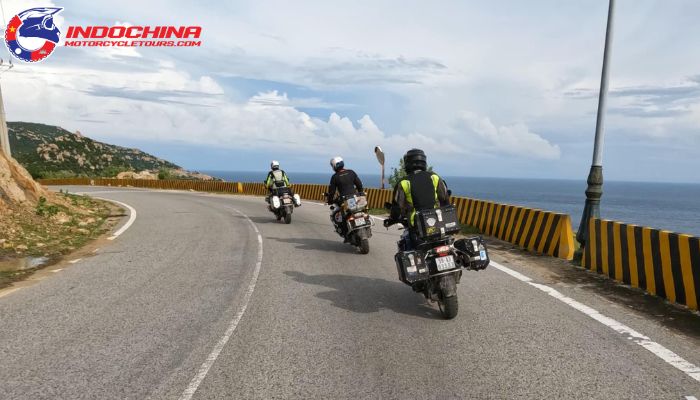 Three motorcyclists riding along a scenic coastal road, enjoying their tour